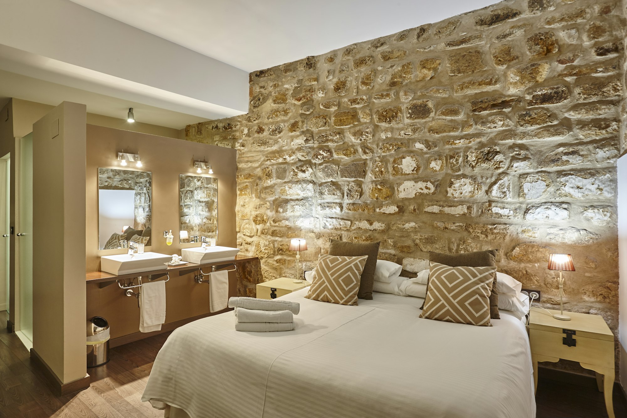 Bedroom with stone walls. Comfortable modern hotel room. Interior